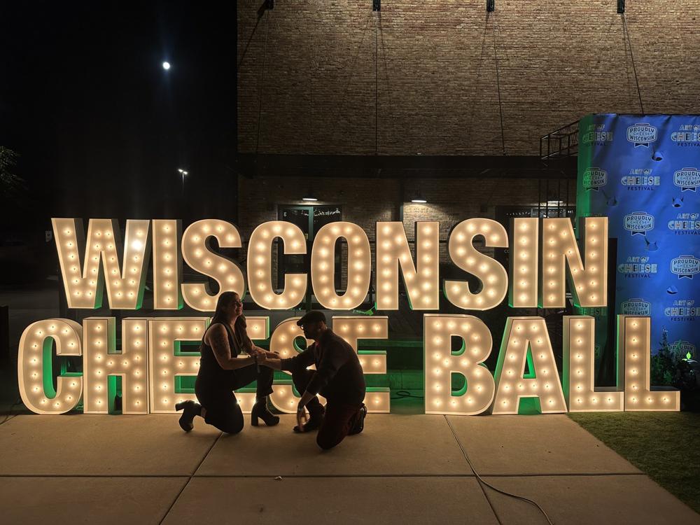 Marquee-light letters spelling Wisconsin Cheese Ball at night