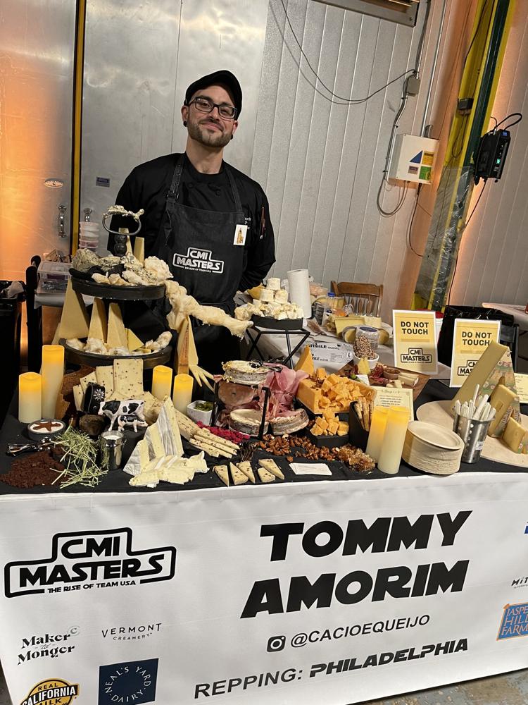 Tommy at his Cheesemonger Invitational Masters table covered in cheese