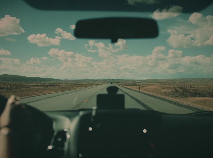 View through a windshield down an open highway
